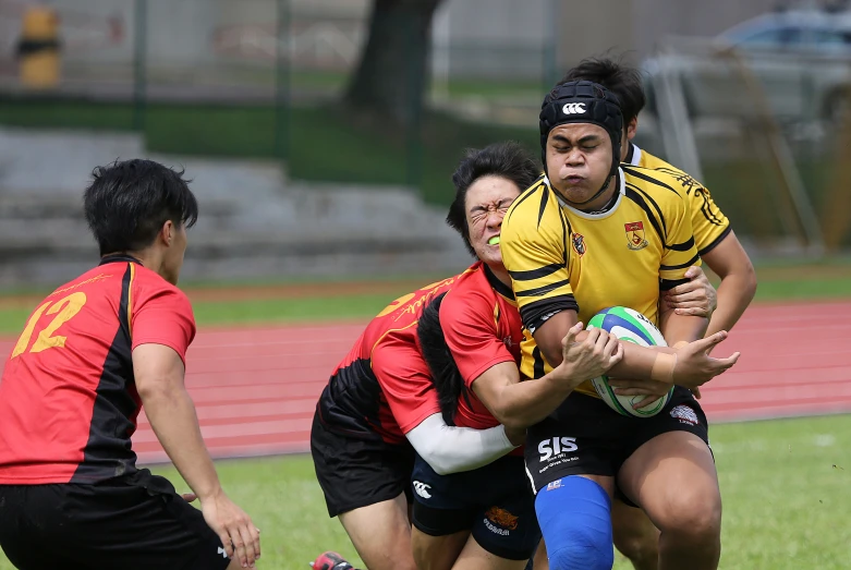 a group of men are playing rugby in a field