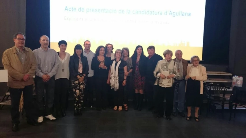 a group of people standing on a stage in front of a screen