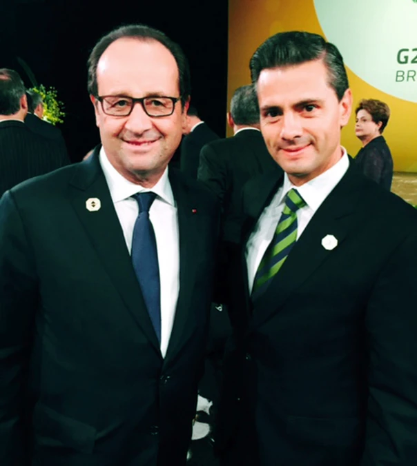 two men are smiling for the camera while wearing suits