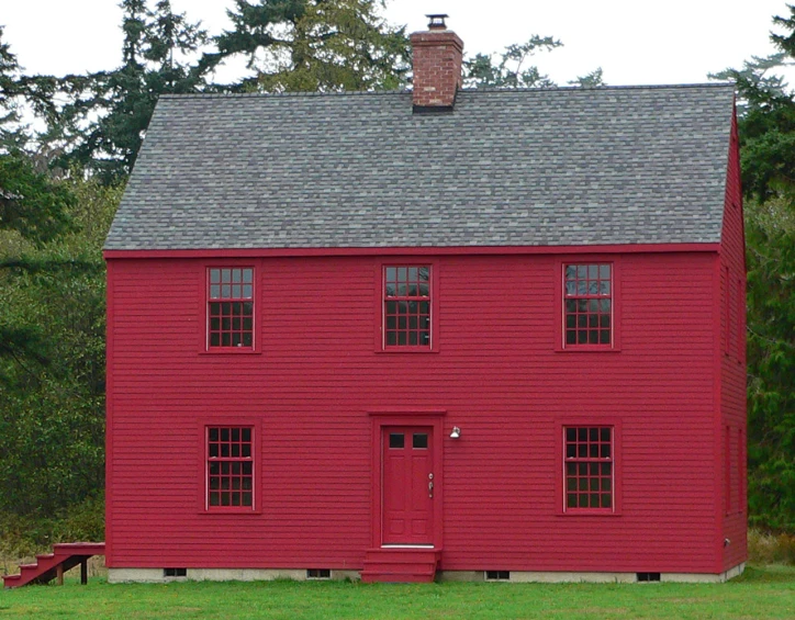 a very large red house with windows and red door