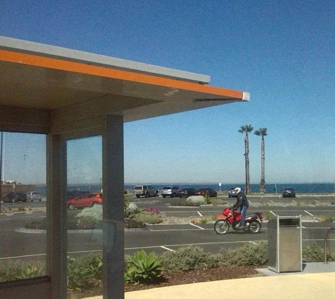 there is a man on a motorcycle that is at an empty gas station