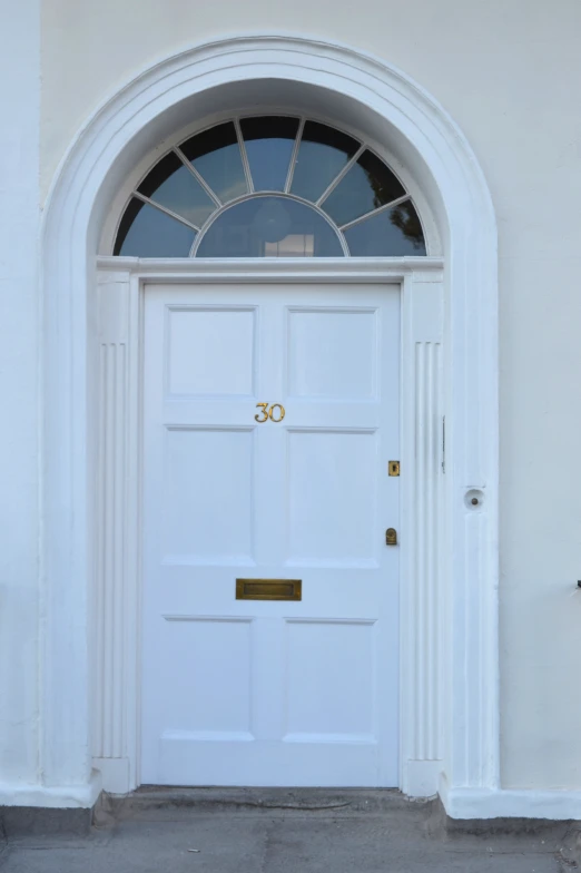 a white door sitting under a window next to a sidewalk