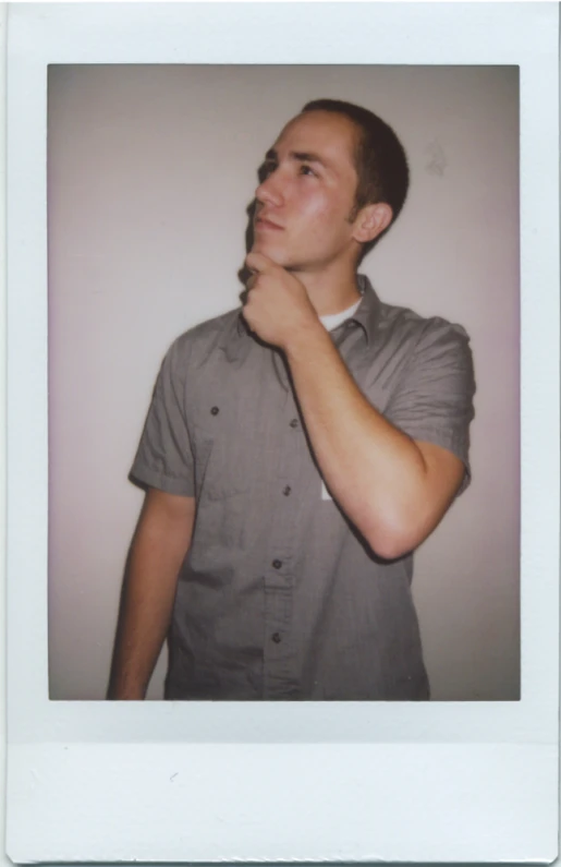 an adult standing in front of a white wall brushing his teeth