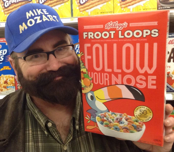 a man with a beard holding up a cereal box