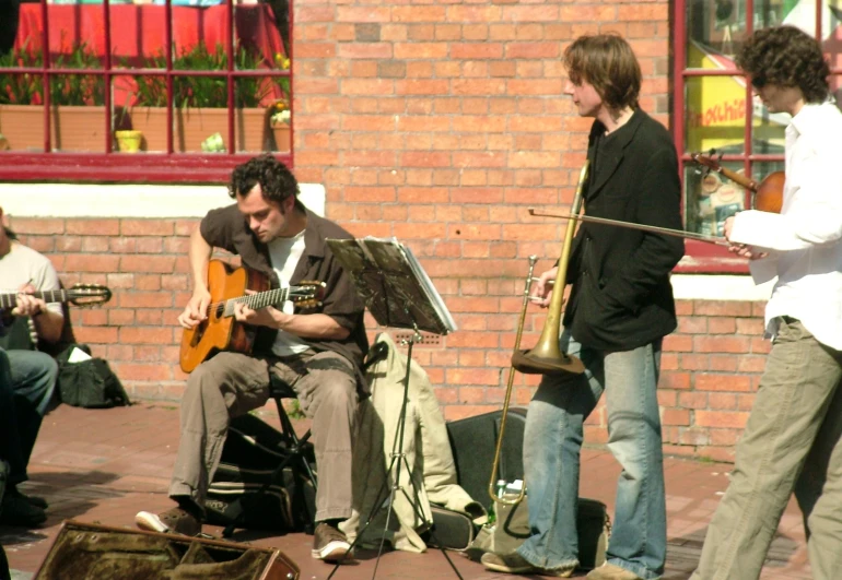 a group of men playing instruments and sitting