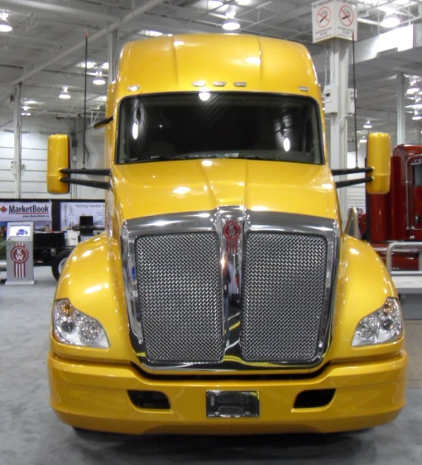 yellow truck with chrome front grills in a garage