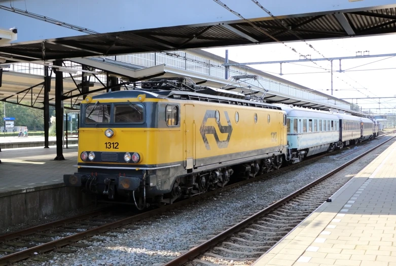 a yellow train sitting on top of a track