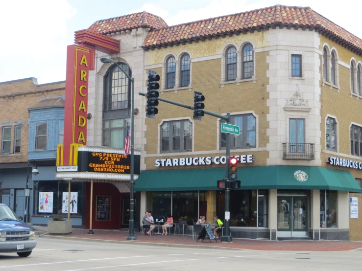 a view of a street corner with a coffee shop and a movie theater