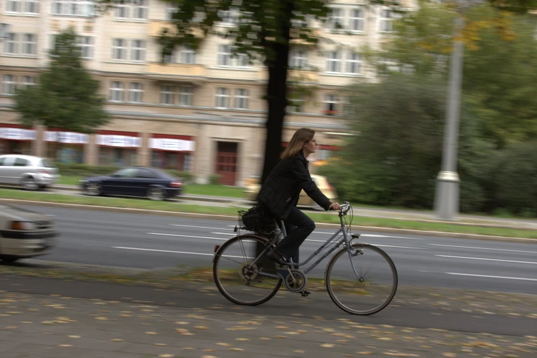 a girl riding a bike in a black coat