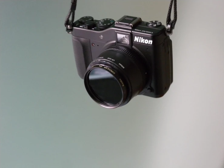 a camera is hanging on a white wall