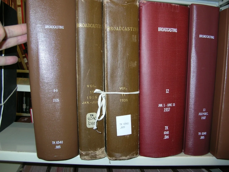 an image of books in a shelf with a finger