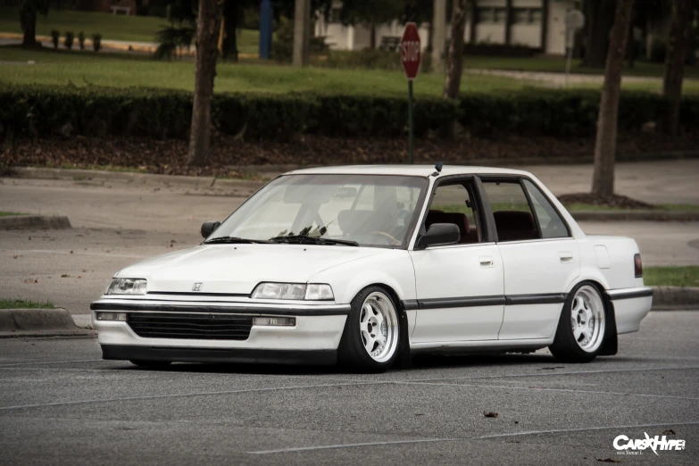 white station wagon parked in lot next to trees