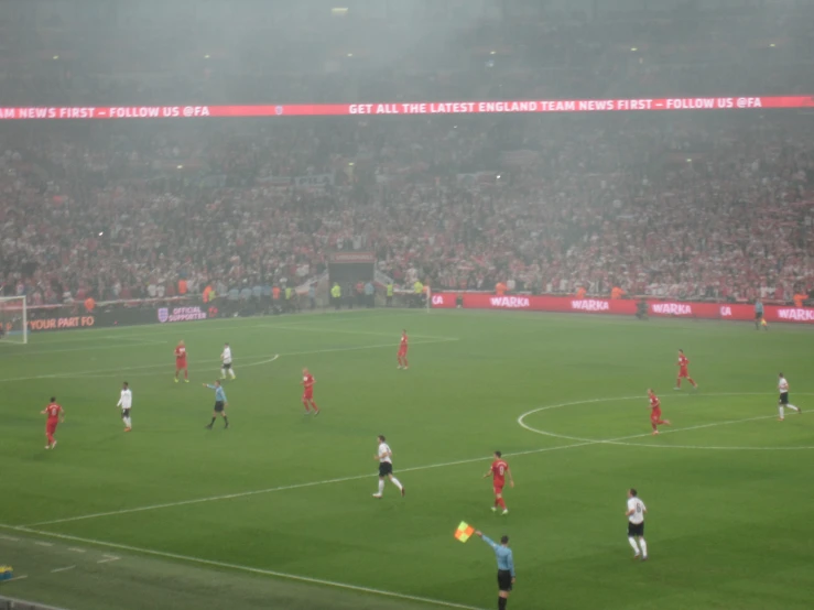 several teams of people are playing soccer on a foggy day