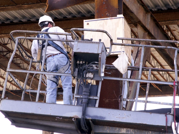 construction worker on a crane fixing an electrical cable