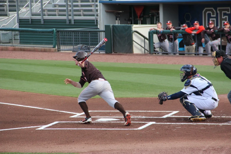 baseball player waiting to bat during game being watched by crowd