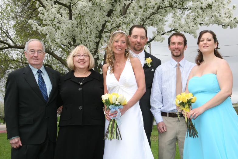 people are posing for a picture while a man is standing by the woman