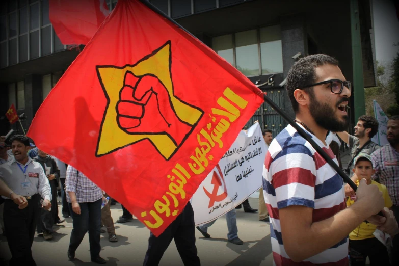 there is a man holding a flag in the middle of a group