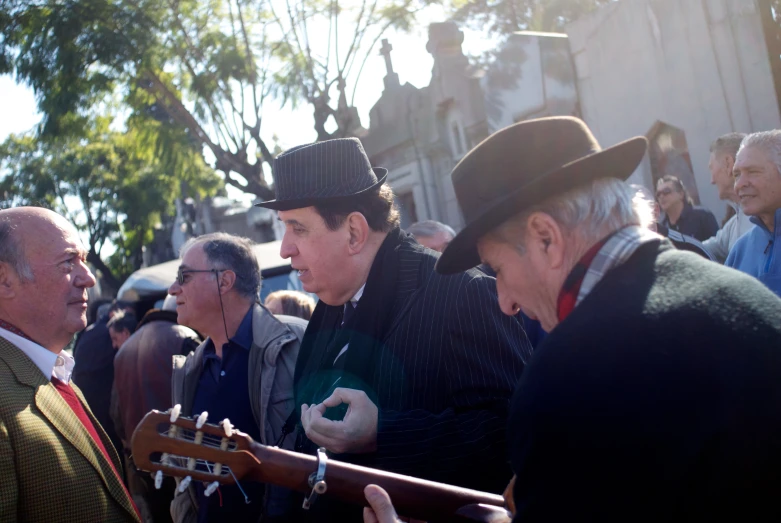 a group of people that are standing around with some guitar