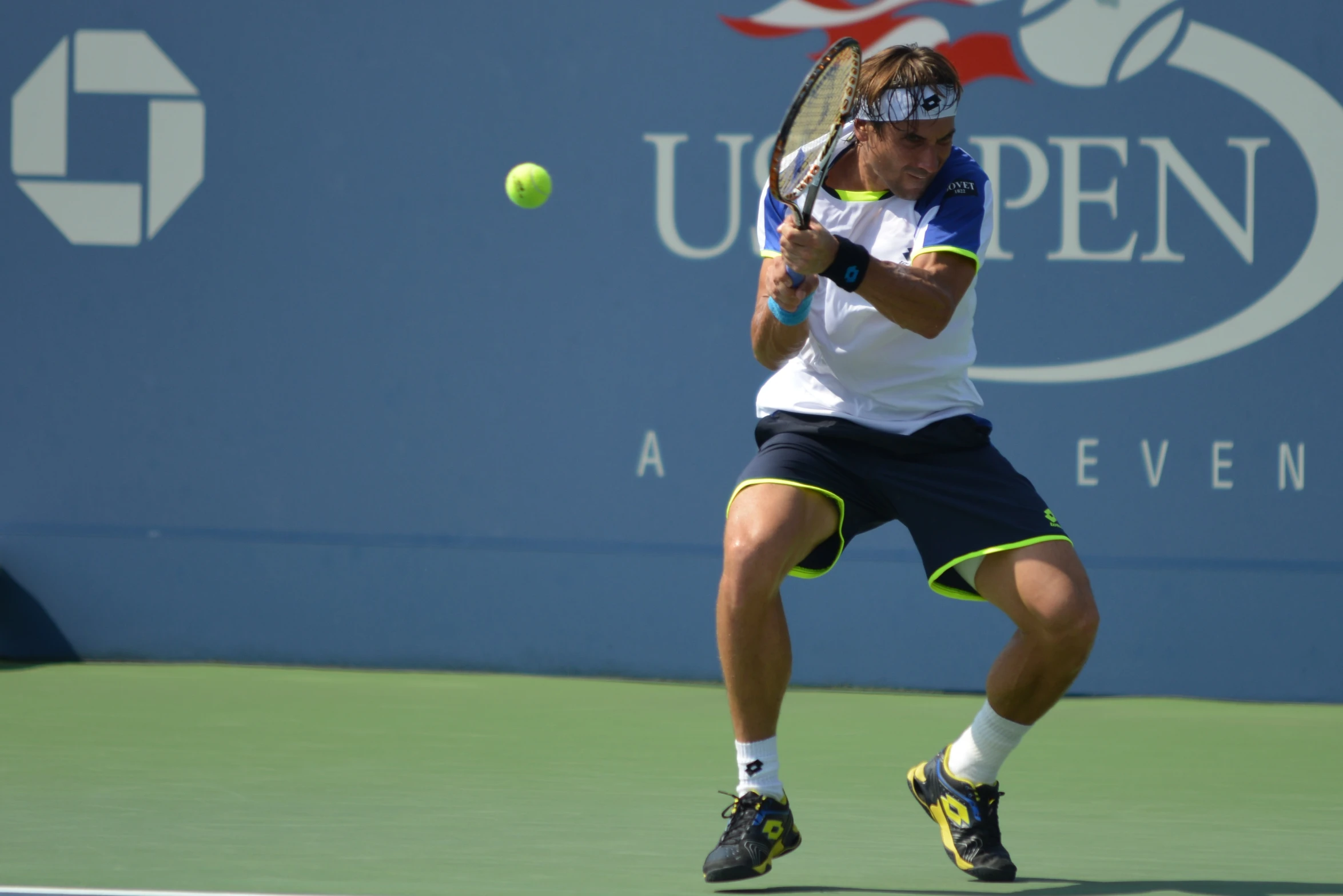 a man hitting a tennis ball with his tennis racket