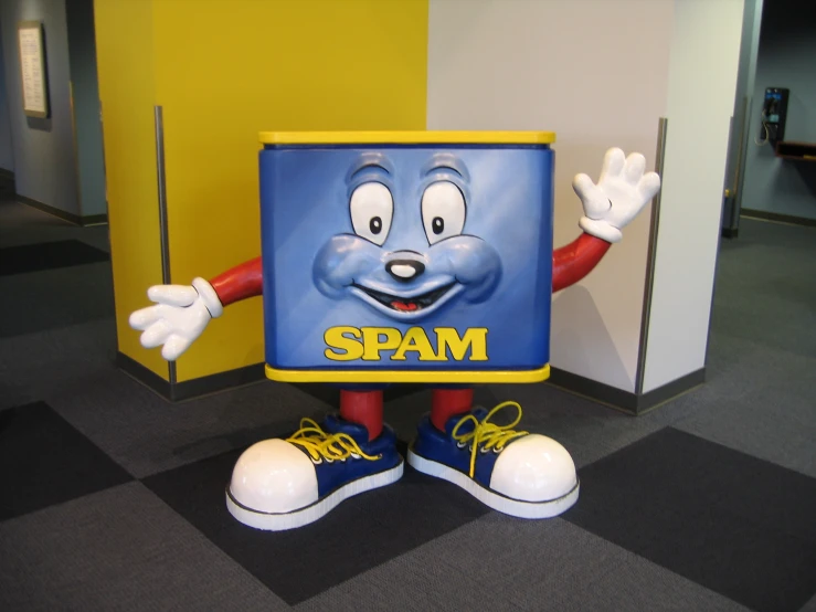a sculpture of a cartoon character in yellow and blue stands in a room