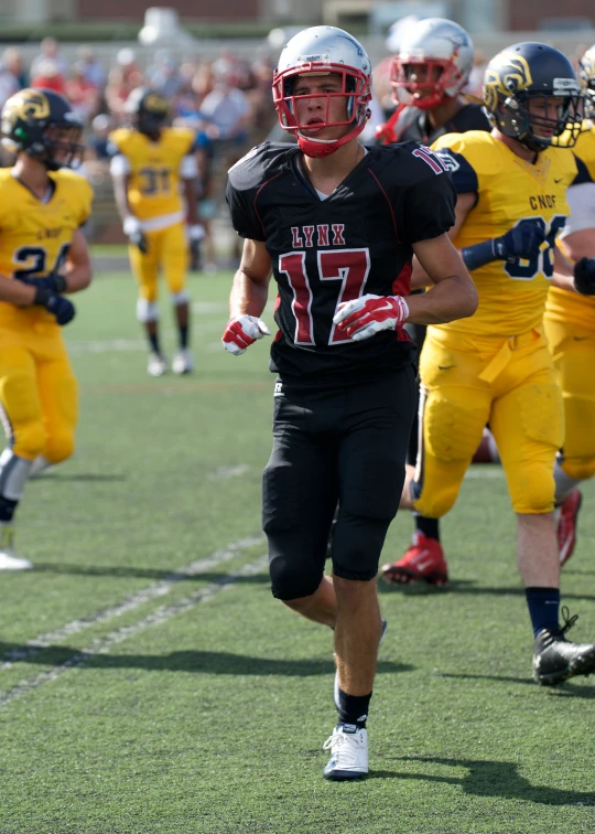 there is a male football player in a uniform and two men in the background