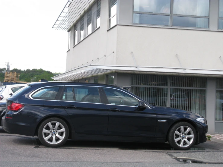 the side of a bmw car parked in front of a building