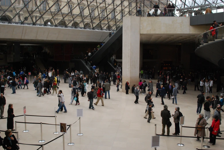 large crowd of people walking around a very busy atrium