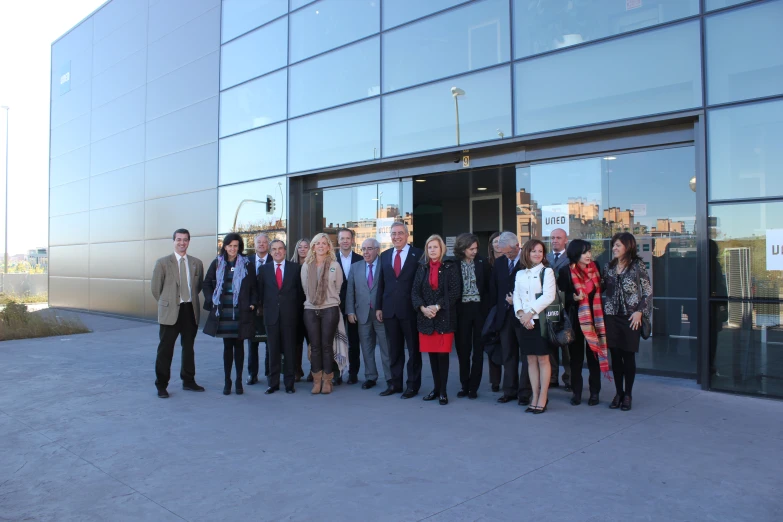 people stand in front of a glass building