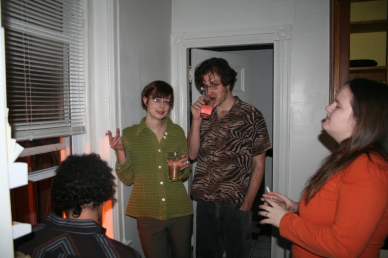 a group of young people standing around in the living room