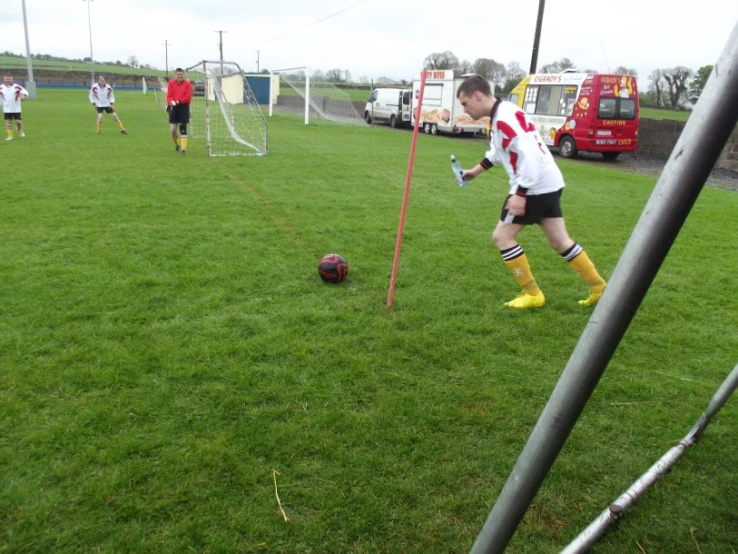 a young man is kicking a soccer ball in the grass