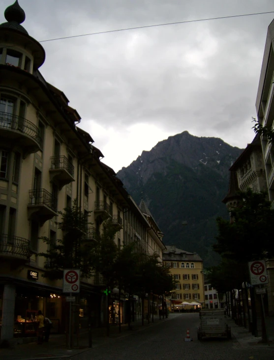 looking up the street to some buildings and a mountain range in the distance