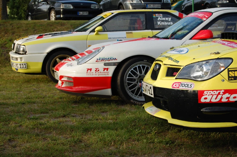 two yellow and red cars in line on the grass