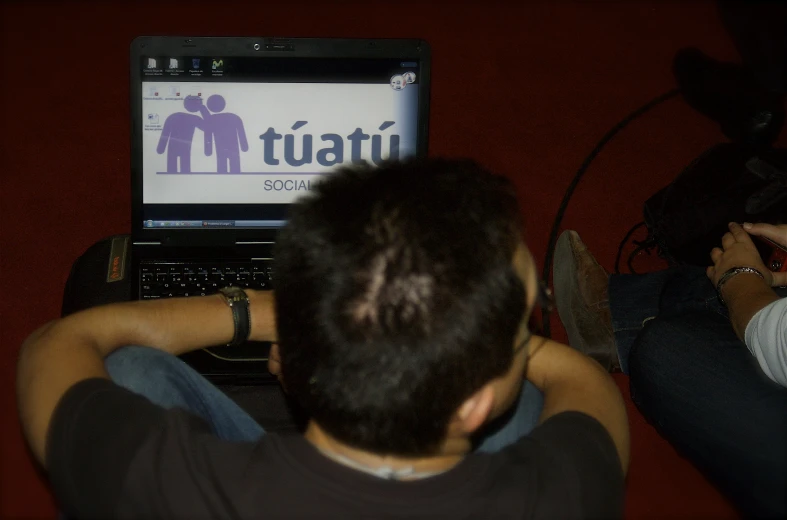 a man is looking at a laptop screen