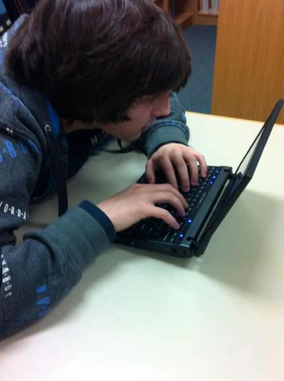 a young man with a backpack using a laptop computer