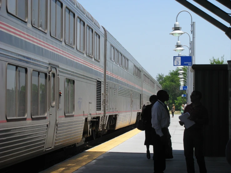 the people are waiting outside of a train