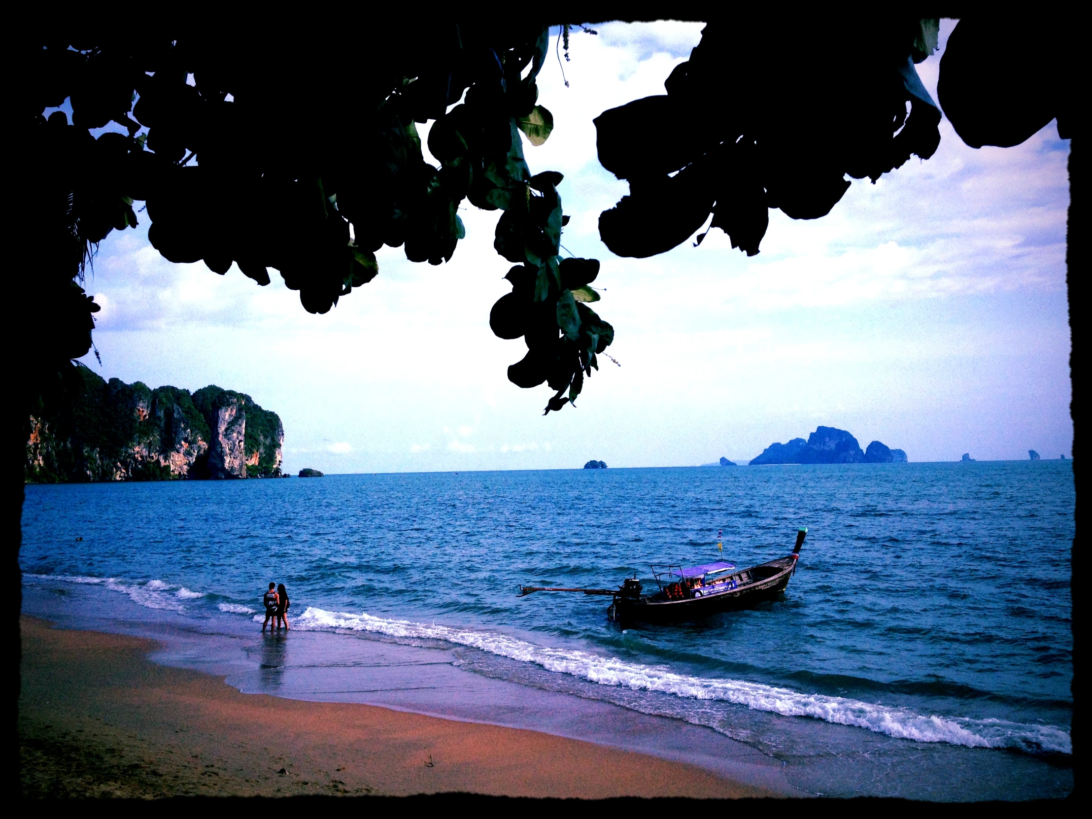 a boat on the water with two people standing in it