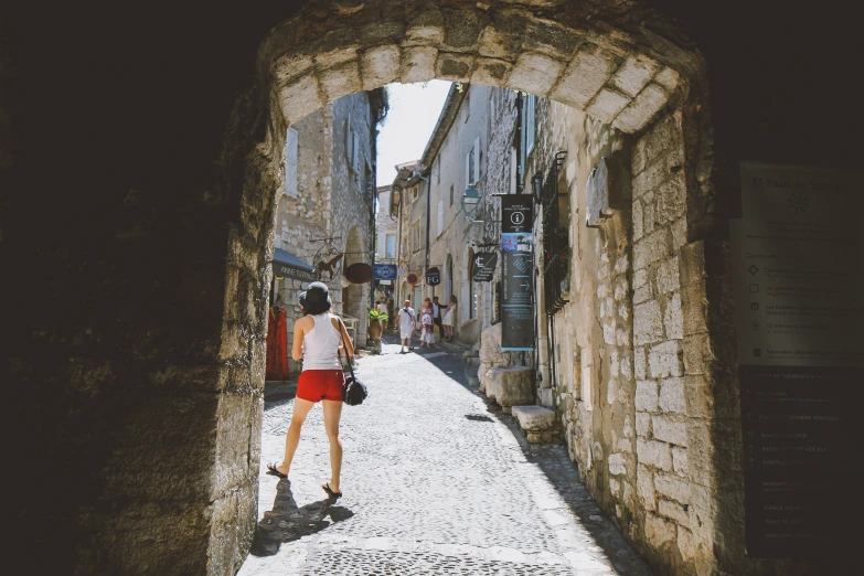 a girl walks through an alleyway as she holds onto her purse