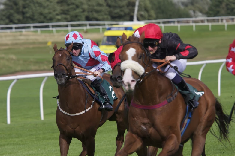 people are riding horses and wearing jockey costumes