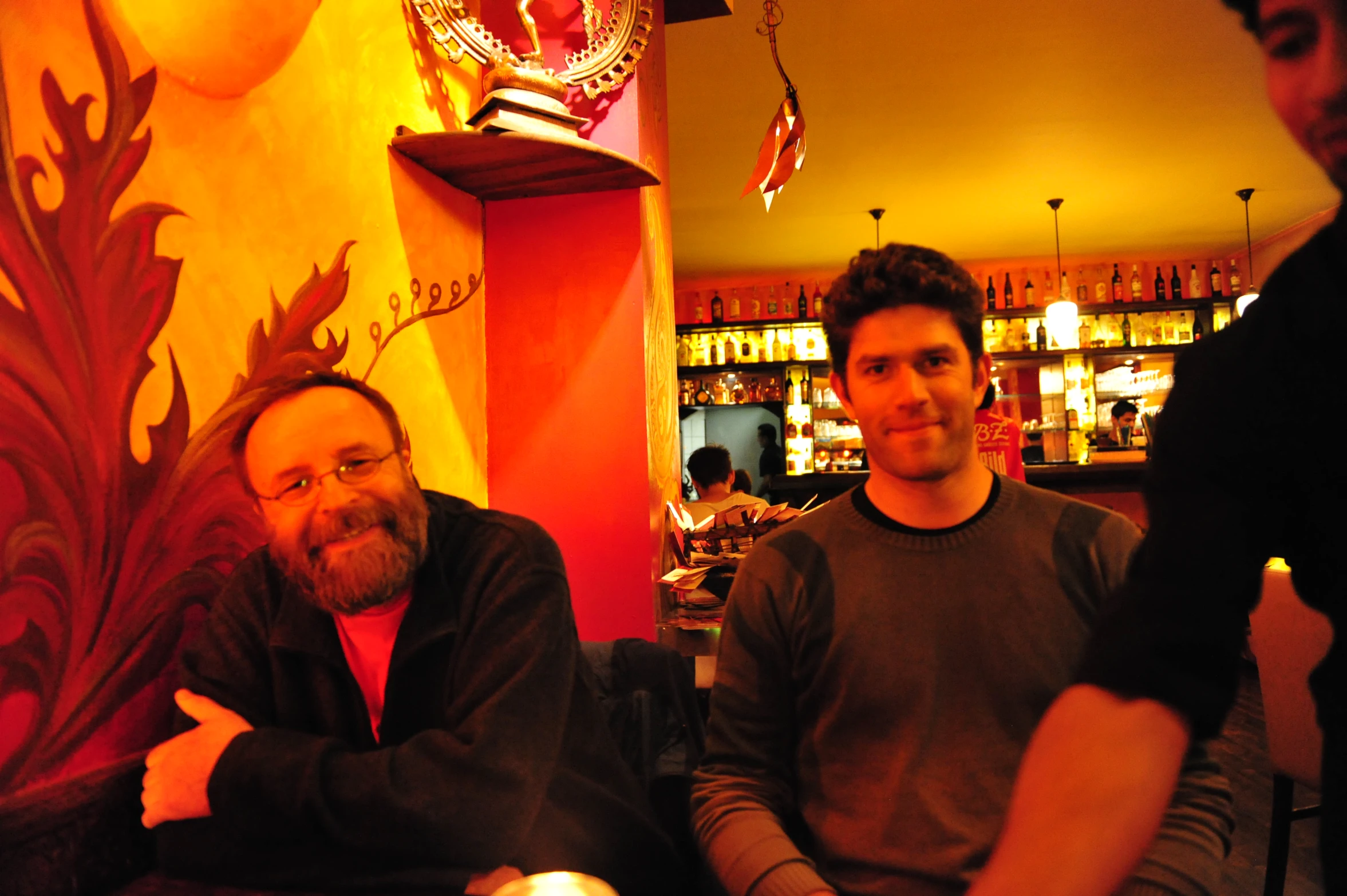 two men sitting at a table with their arms folded