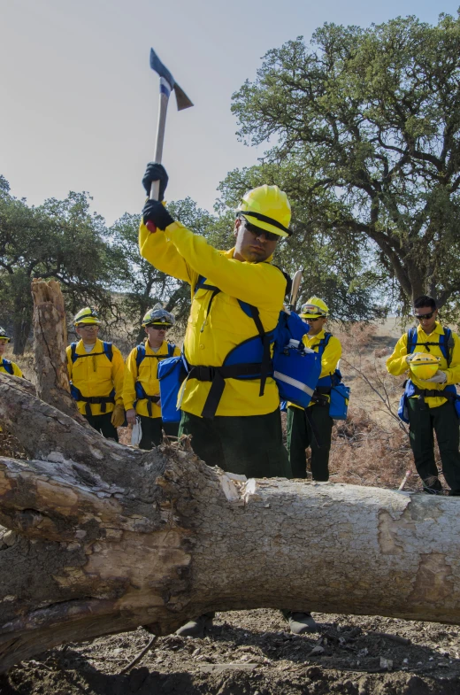 a man wearing a helmet while holding up two axes