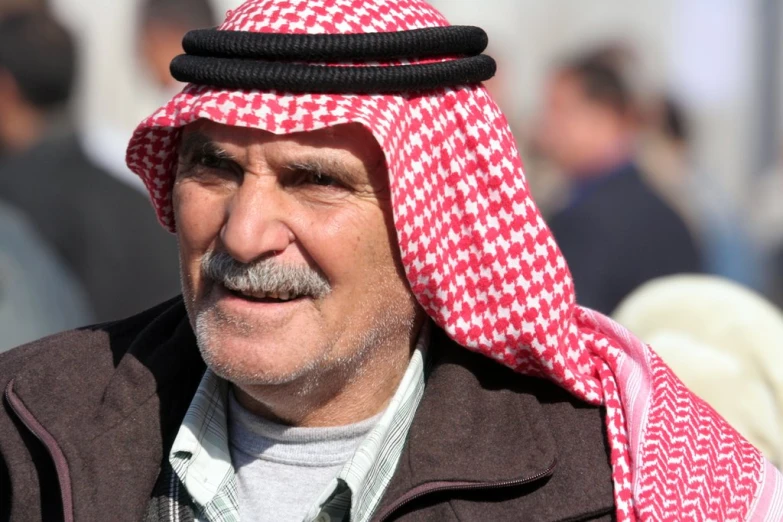 a man with a black nose ring wearing a red, white and black checkered hat