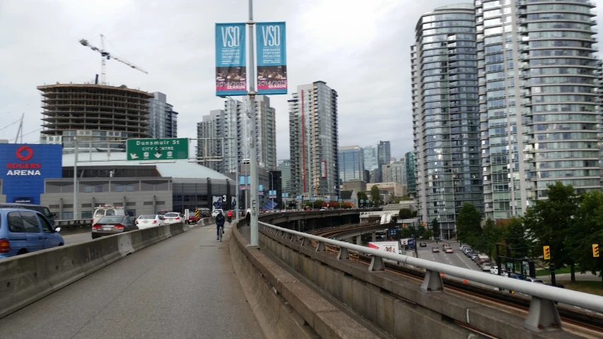 a street with a sign and some very tall buildings