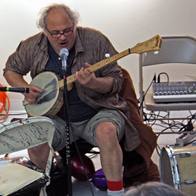 a man that is sitting down with a guitar