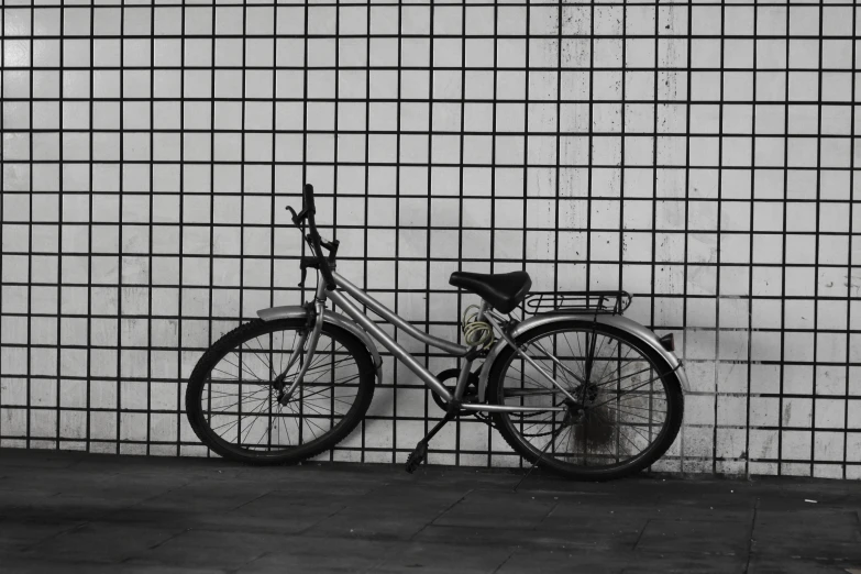 a bicycle parked in front of a tiled wall