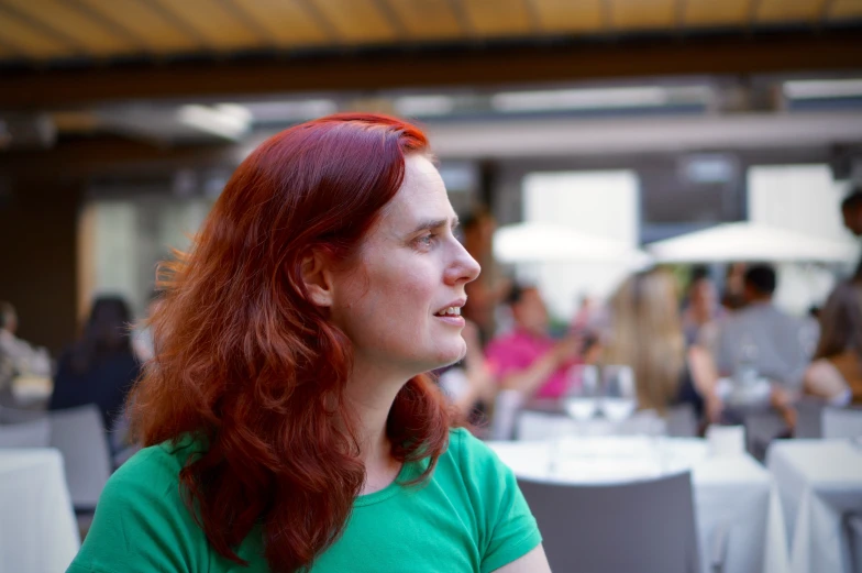woman with red hair is looking in a restaurant