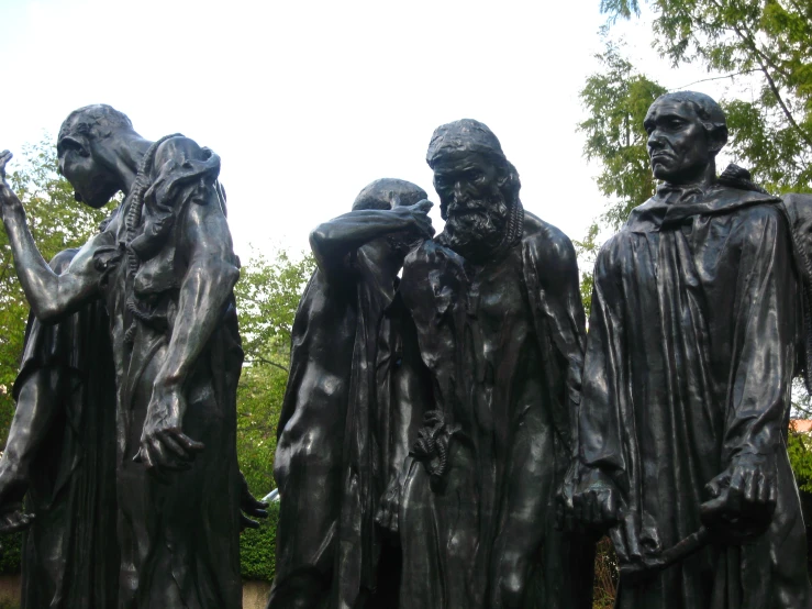 several statues of men stand near each other
