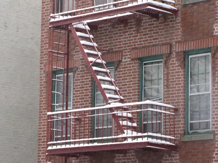 a snow covered fire escape near an apartment building