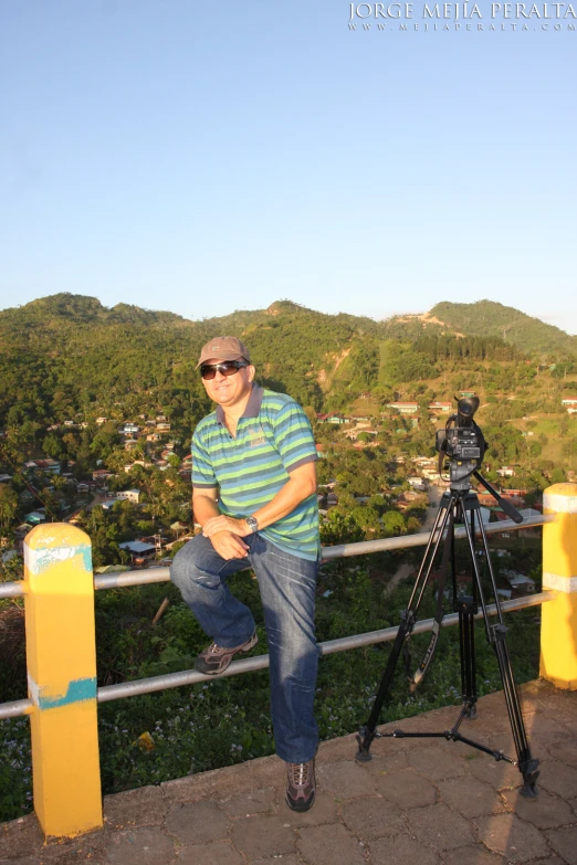 a man on a hill with a video camera