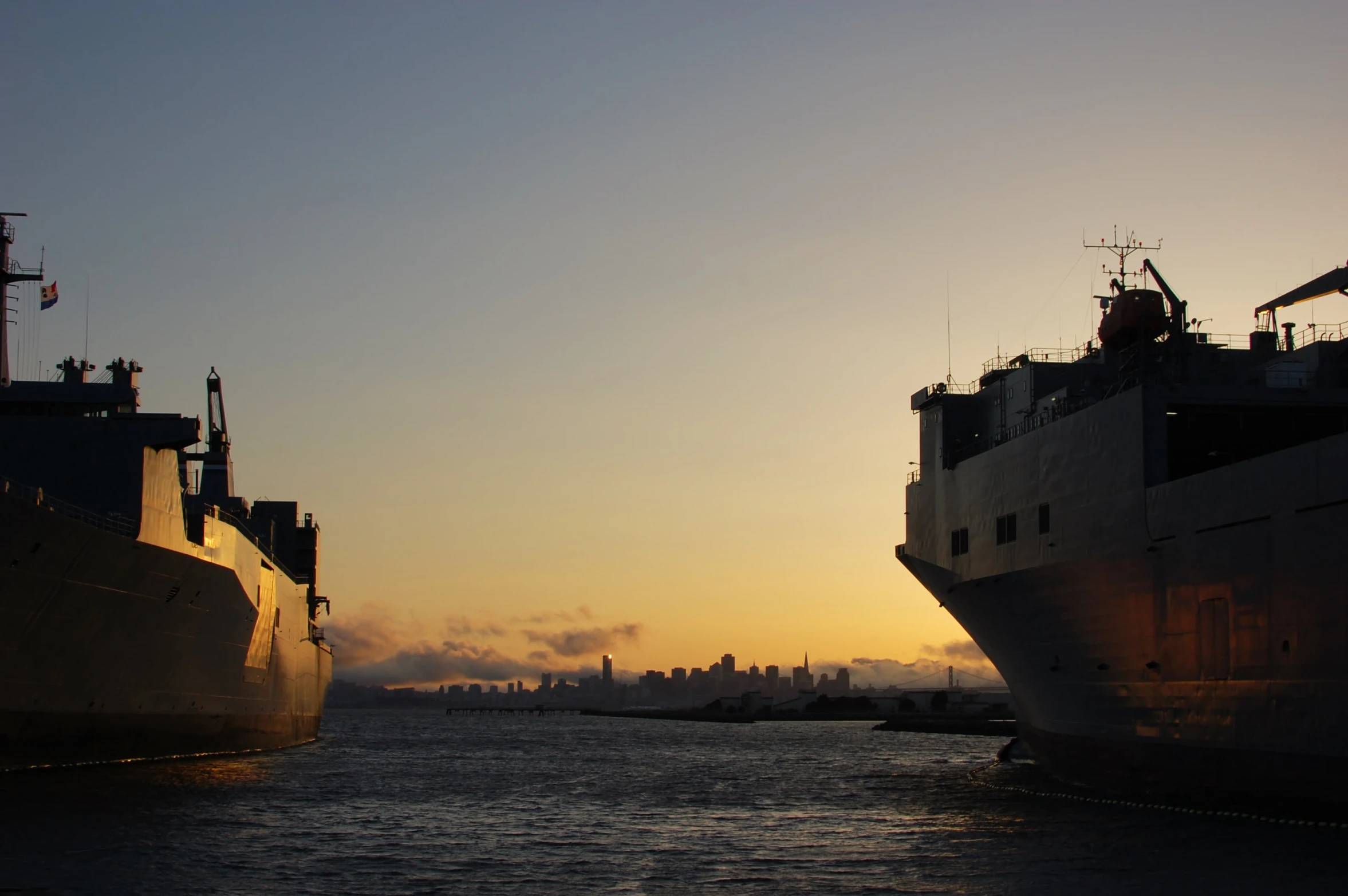 there are two large ships at sunset on the water