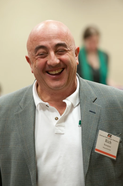 smiling man in blazer standing indoors at work